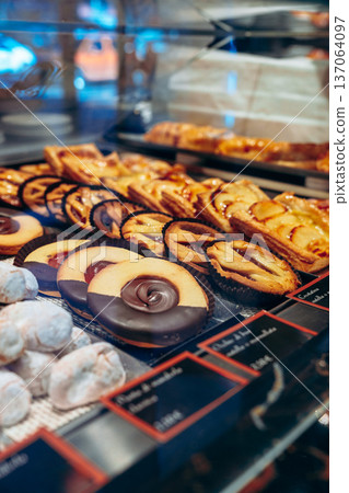 Fresh variety of pastries on display in a bakery during the afternoon 137064097