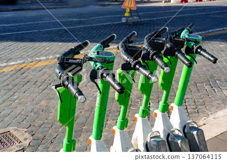 Scooters parked on city street during the day near pavement and traffic signs Scooters parked on city street during the day near pavement and traffic signs 137064115
