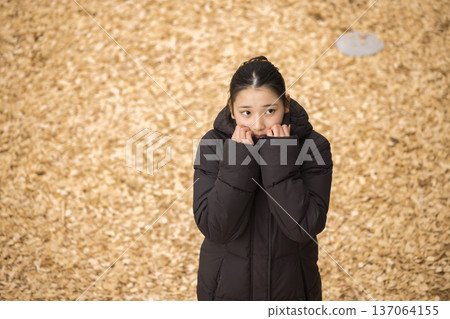一個穿著外套、感到寒冷的女孩 137064155
