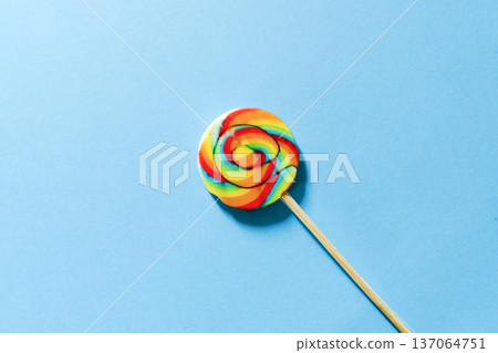 Swirl lollipop on a blue background colorful candy concept Swirl lollipop on a blue background colorful candy concept 137064751