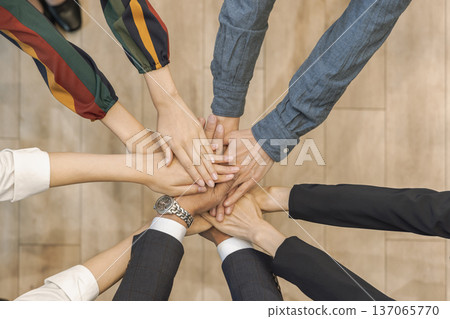 Business hands stacked in a circle, overhead view 137065770