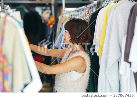 年輕女子在二手服飾店挑選衣服 年輕女子在二手服飾店挑選衣服 137067436