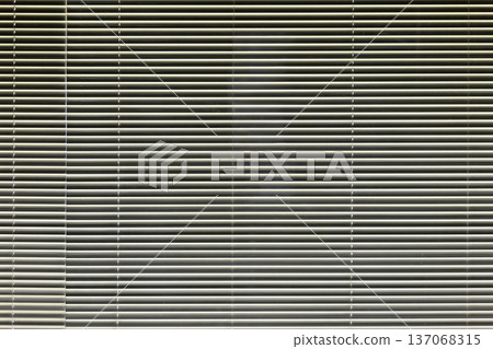 A night scene with light filtering through the gaps in the aluminum blinds on the window. A night scene with light filtering through the gaps in the aluminum blinds on the window. 137068315
