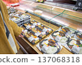 一位女士在超市裡挑選了一份貼有折扣標籤的盒裝午餐或預製食品。 137068318