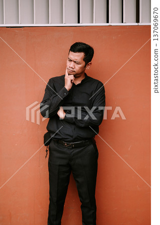Thoughtful Man in Black Shirt Pondering a Solution Deeply Thoughtful Man in Black Shirt Pondering a Solution Deeply 137069670