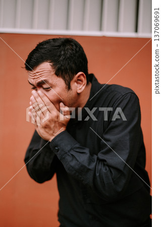 Adult man covering his mouth and nose, feeling unwell Adult man covering his mouth and nose, feeling unwell 137069691