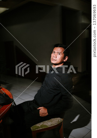 Dramatic portrait of an introspective man in shadows Dramatic portrait of an introspective man in shadows 137069693