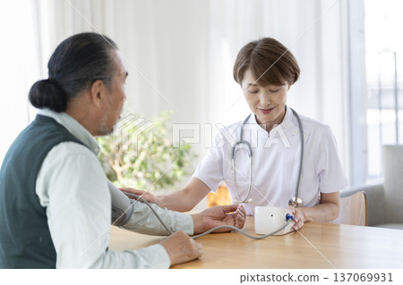 Veteran medical staff measuring the blood pressure of a senior man 137069931