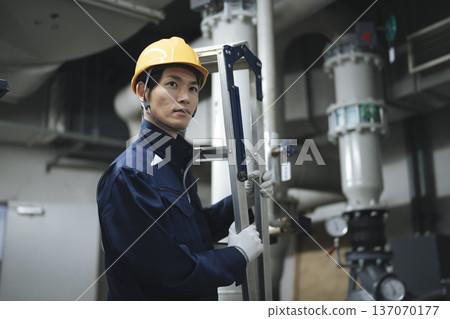 Workers working in the building equipment machine room 137070177