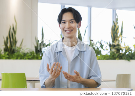A smiling man in his thirties talking looking at the camera 137070181