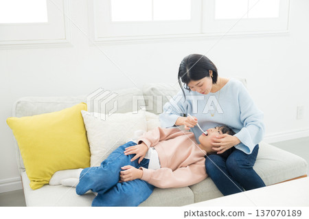 一位母親正在為她的小學生孩子做最後的潤飾。 一位母親正在為她的小學生孩子做最後的潤飾。 137070189