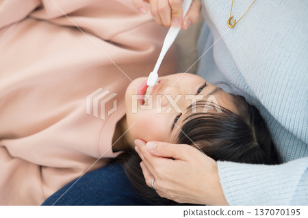 一位母親正在為她的小學生孩子做最後的潤飾。 一位母親正在為她的小學生孩子做最後的潤飾。 137070195