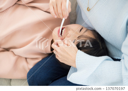 一位母親正在為她的小學生孩子做最後的潤飾。 一位母親正在為她的小學生孩子做最後的潤飾。 137070197