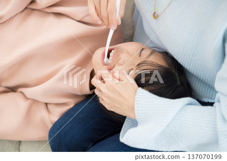 一位母親正在為她的小學生孩子做最後的潤飾。 一位母親正在為她的小學生孩子做最後的潤飾。 137070199