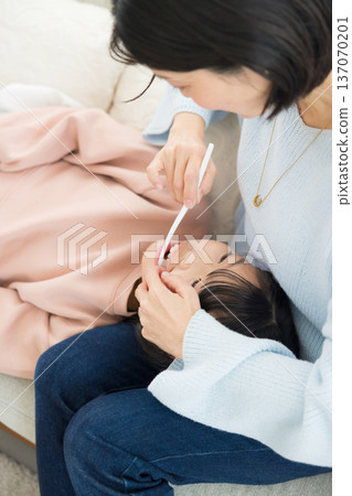 一位母親正在為她的小學生孩子做最後的潤飾。 一位母親正在為她的小學生孩子做最後的潤飾。 137070201