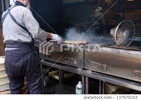 Man grilling eel 137070283