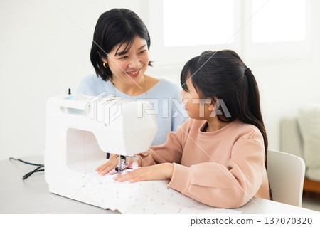 A woman sewing with a sewing machine 137070320