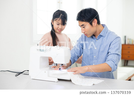 Man sewing with a sewing machine 137070339