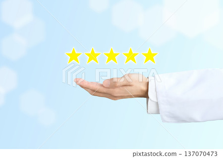 Five star rating and the hand of a person in a white coat 137070473