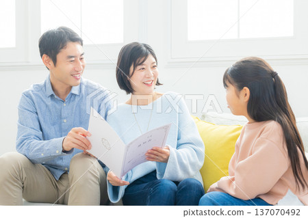 Family looking at report cards in the living room 137070492