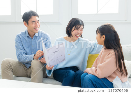 Family looking at report cards in the living room 137070496
