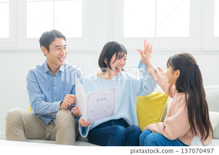 Family looking at report cards in the living room Family looking at report cards in the living room 137070497