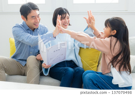 Family looking at report cards in the living room Family looking at report cards in the living room 137070498
