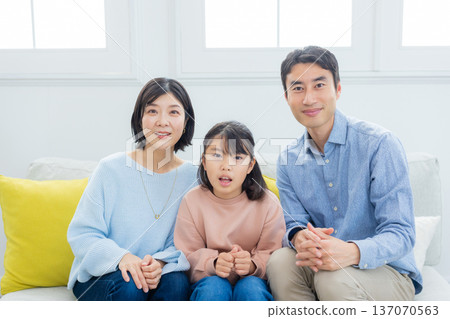 family looking at tablet in living room family looking at tablet in living room 137070563