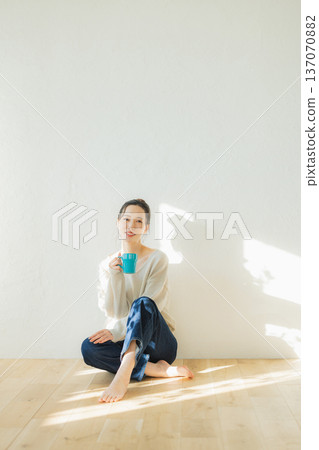 少婦坐地板和飲用的咖啡 少婦坐地板和飲用的咖啡 137070882