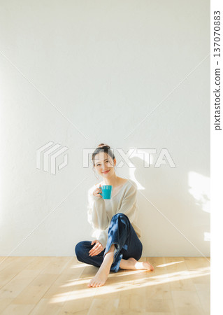 少婦坐地板和飲用的咖啡 少婦坐地板和飲用的咖啡 137070883