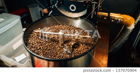 reshly roasted coffee beans mixing in a commercial coffee roaster machine. 137070904