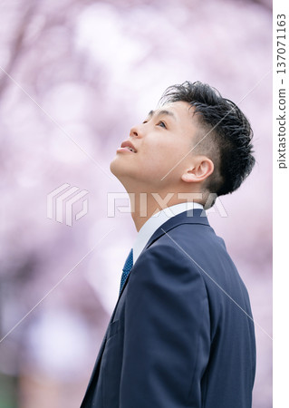 Freshman young man in suit looking up Freshman young man in suit looking up 137071163