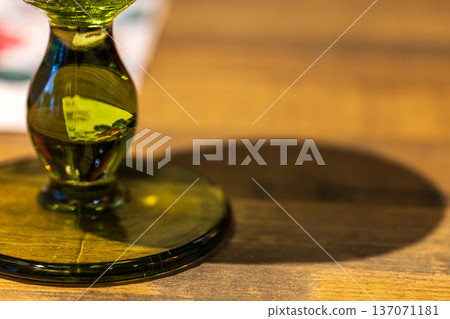 翠綠玻璃杯腳與木質桌面上的光影折射 翠綠玻璃杯腳與木質桌面上的光影折射 137071181