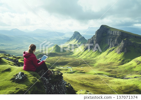 Digital Entrepreneur Sitting on Mountaintop with Tablet in Serene Landscape Scene Digital Entrepreneur Sitting on Mountaintop with Tablet in Serene Landscape Scene 137071374