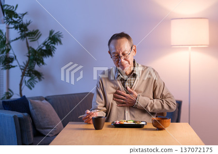 Senior man eating lunch, stomach upset Senior man eating lunch, stomach upset 137072175