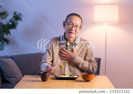一位老年男子正在吃午飯，突然胃部不適 137072182