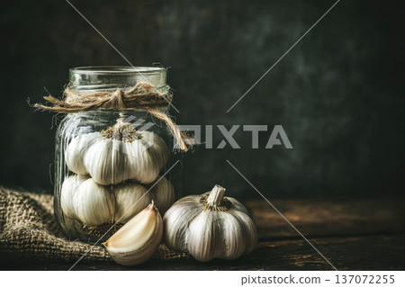 Fresh Garlic Cloves in Glass Jar with Rustic Background and Twine Decor Fresh Garlic Cloves in Glass Jar with Rustic Background and Twine Decor 137072255