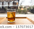 Enjoying iced tea by the window (glass with ice, cafe scene) 137073017