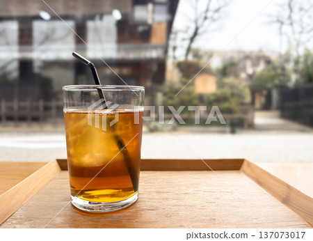 Enjoying iced tea by the window (glass with ice, cafe scene) Enjoying iced tea by the window (glass with ice, cafe scene) 137073017