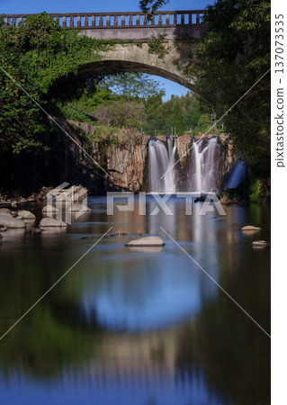 Bridge and waterfall reflected on the water surface Bridge and waterfall reflected on the water surface 137073535