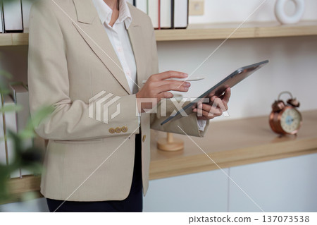 Business Professional Using Tablet in Modern Office Business Professional Using Tablet in Modern Office 137073538