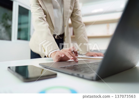 Business Professional Engaging with Laptop in Modern Office 137073563