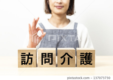 一位身穿圍裙、手持寫有「居家照護」字樣積木的女士 137073730