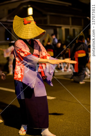 A woman wearing a straw hat and a hem-stitched kimono dances at the Nishimonai Bon Odori festival in Akita Prefecture. 137073811