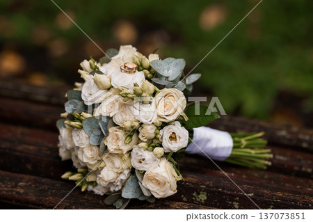 Elegant White Wedding Bouquet with Gold Rings on Rustic Wooden Surface, Soft Focus Background, Romantic and Natural Aesthetic Elegant White Wedding Bouquet with Gold Rings on Rustic Wooden Surface, Soft Focus Background, Romantic and Natural Aesthetic 137073851