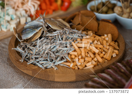 Fresh Anchovies and Crispy Bread Sticks Arranged on Wooden Tray with Assorted Snacks and Appetizers in Rustic Style Fresh Anchovies and Crispy Bread Sticks Arranged on Wooden Tray with Assorted Snacks and Appetizers in Rustic Style 137073872