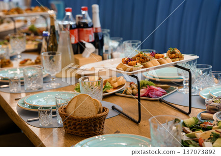 Elegant Buffet Table Setup with Gourmet Appetizers, Fresh Bread, and Drinks in a Warm, Inviting Dining Environment Elegant Buffet Table Setup with Gourmet Appetizers, Fresh Bread, and Drinks in a Warm, Inviting Dining Environment 137073892