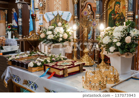 Orthodox Church Interior with Golden Crosses, White Flowers, and Religious Icons in Warm Lighting 137073943