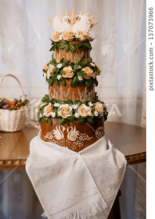 Traditional Ukrainian Wedding Bread Cake Decorated with Swans, Roses, and Wheat Stalks in Earthy Tones Traditional Ukrainian Wedding Bread Cake Decorated with Swans, Roses, and Wheat Stalks in Earthy Tones 137073966