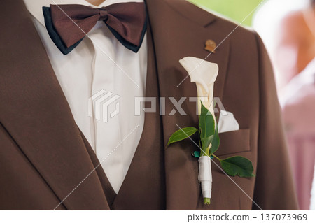 Brown Tuxedo Wedding Suit with White Calla Lily Boutonniere and Bow Tie Close-Up Brown Tuxedo Wedding Suit with White Calla Lily Boutonniere and Bow Tie Close-Up 137073969